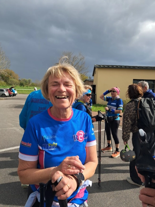 Femme souriante en tenue de marche nordique tenant des bâtons lors d’une sortie à Saint-André-des-Eaux